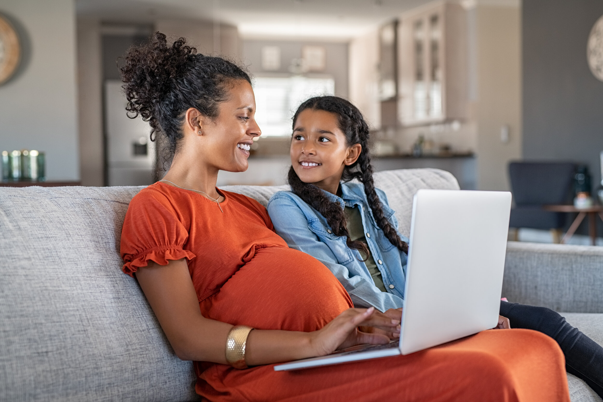 How to Plan for Maternity Leave - Woman with child and computer on couch